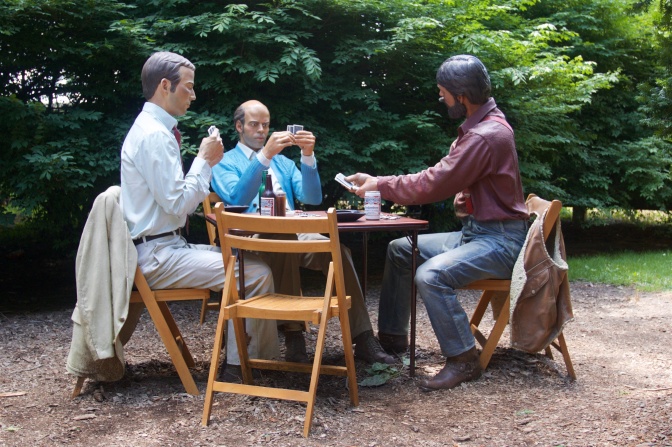 Three men playing cards at a table.