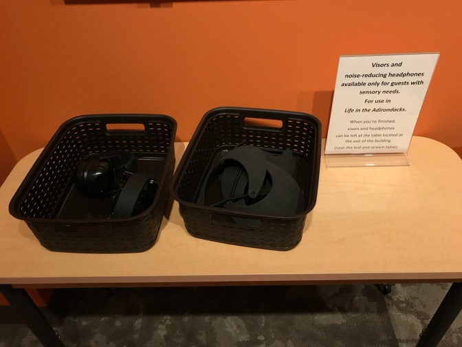 Table with two baskets holding noise-reducing headphones.