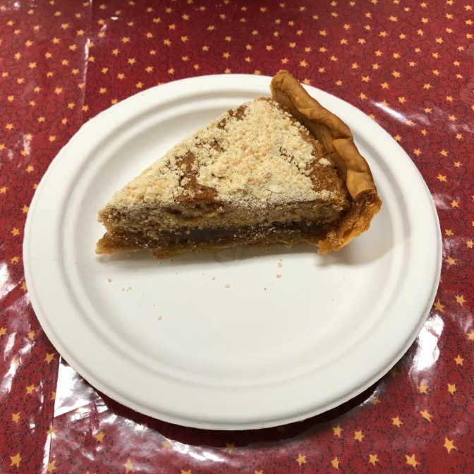 Slice of shoofly pie on white paper plate.