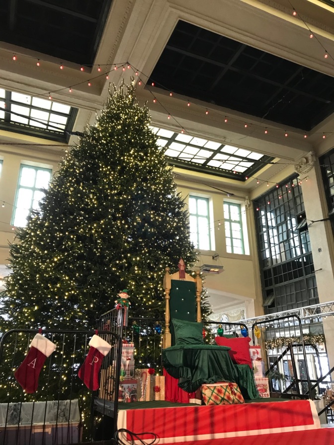 Christmas Tree inside Convention Center, with seat for Santa Claus in foreground.