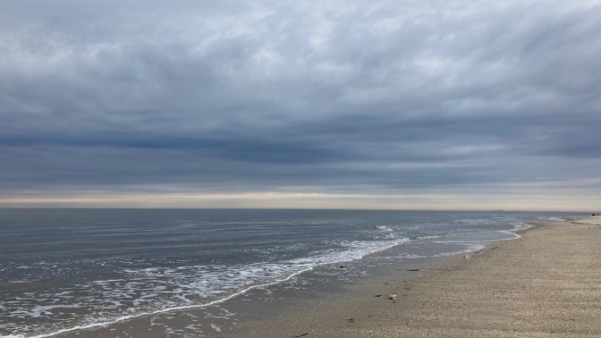 View of beach in Cape May under cloudy skies. 
