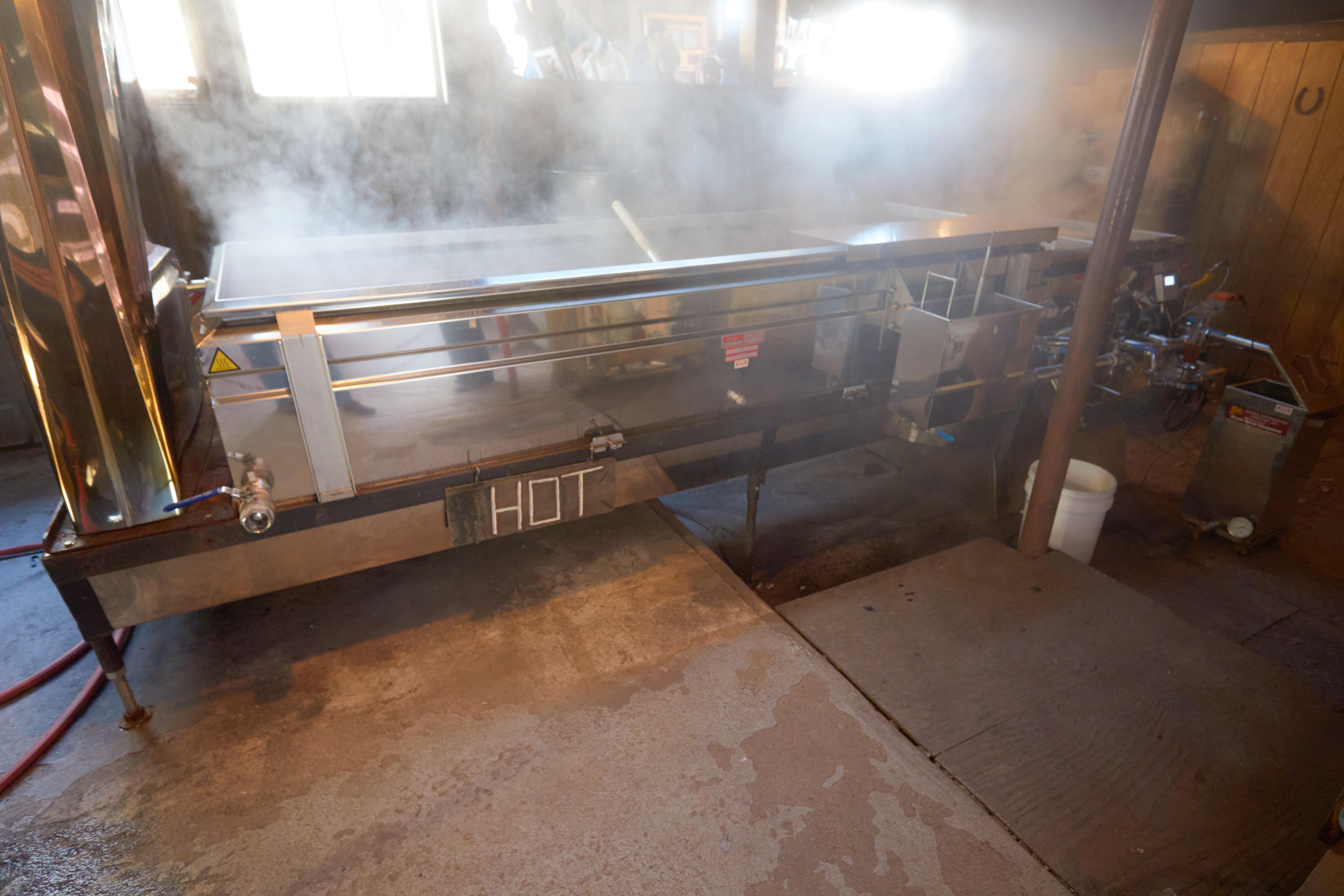 Maple syrup evaporator, with steam rising from top.