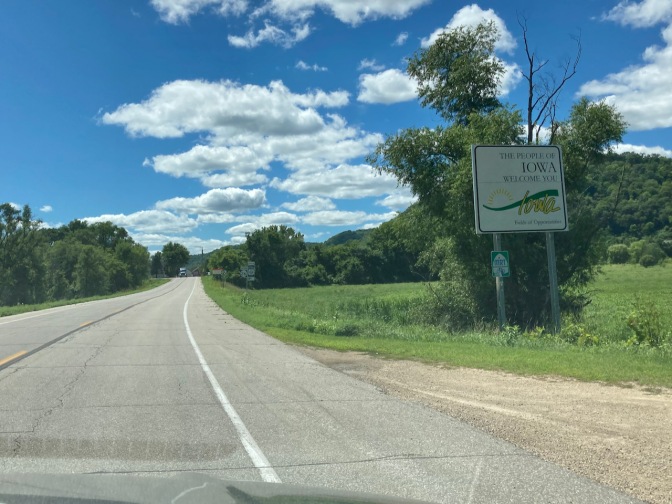 Roadside sign that says THE PEOPLE OF IOWA WELCOME YOU.
