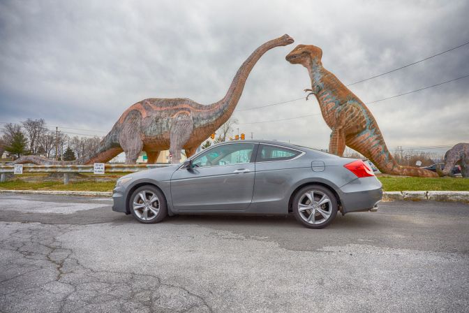 2012 Honda Accord parked in front of two dinosaur sculptures.